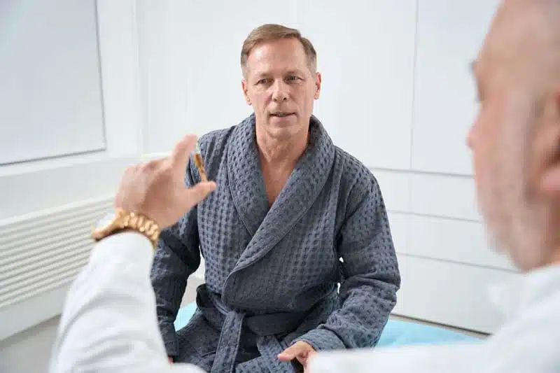 Doctor holding a vial and a man in a blue robe