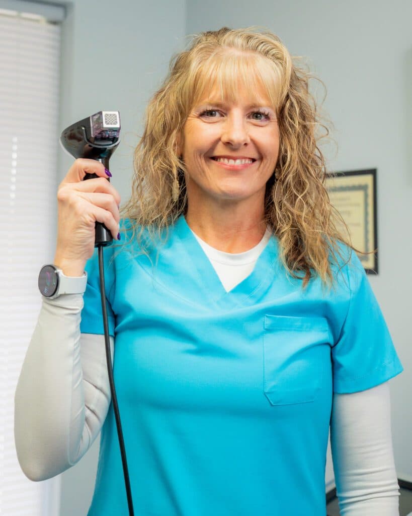 A woman in a blue shirt holds a hair dryer, representing Ivee Restorative Care services.